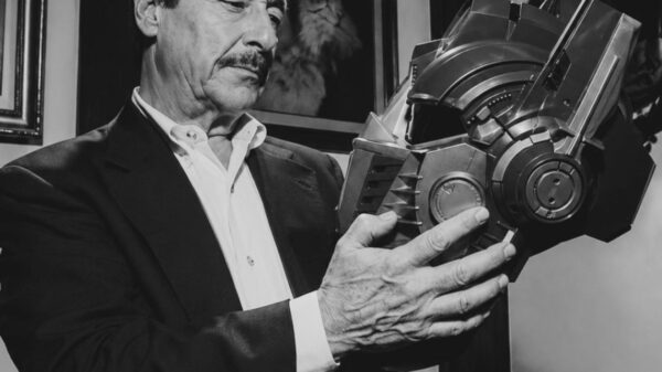Peter Cullen sosteniendo el casco de Optimus Prime en una fotografía en blanco y negro