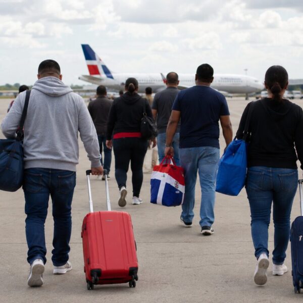 Viajeros dominicanos en un aeropuerto durante un proceso de repatriación
