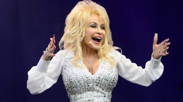 Dolly Parton sonríe durante una presentación sobre el escenario