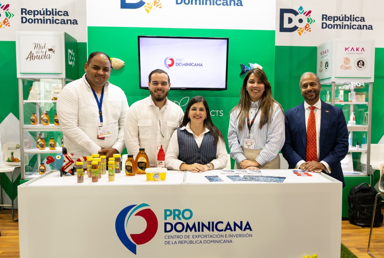 Representantes de ProDominicana promoviendo productos dominicanos en una feria comercial