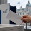 Votante depositando un sobre en una urna electoral de Quebec